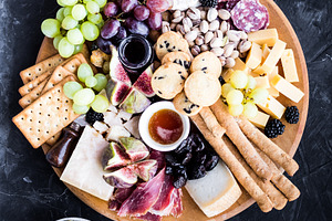 Assortment of tasty appetizers or containing charcuterie, cheese, and platter