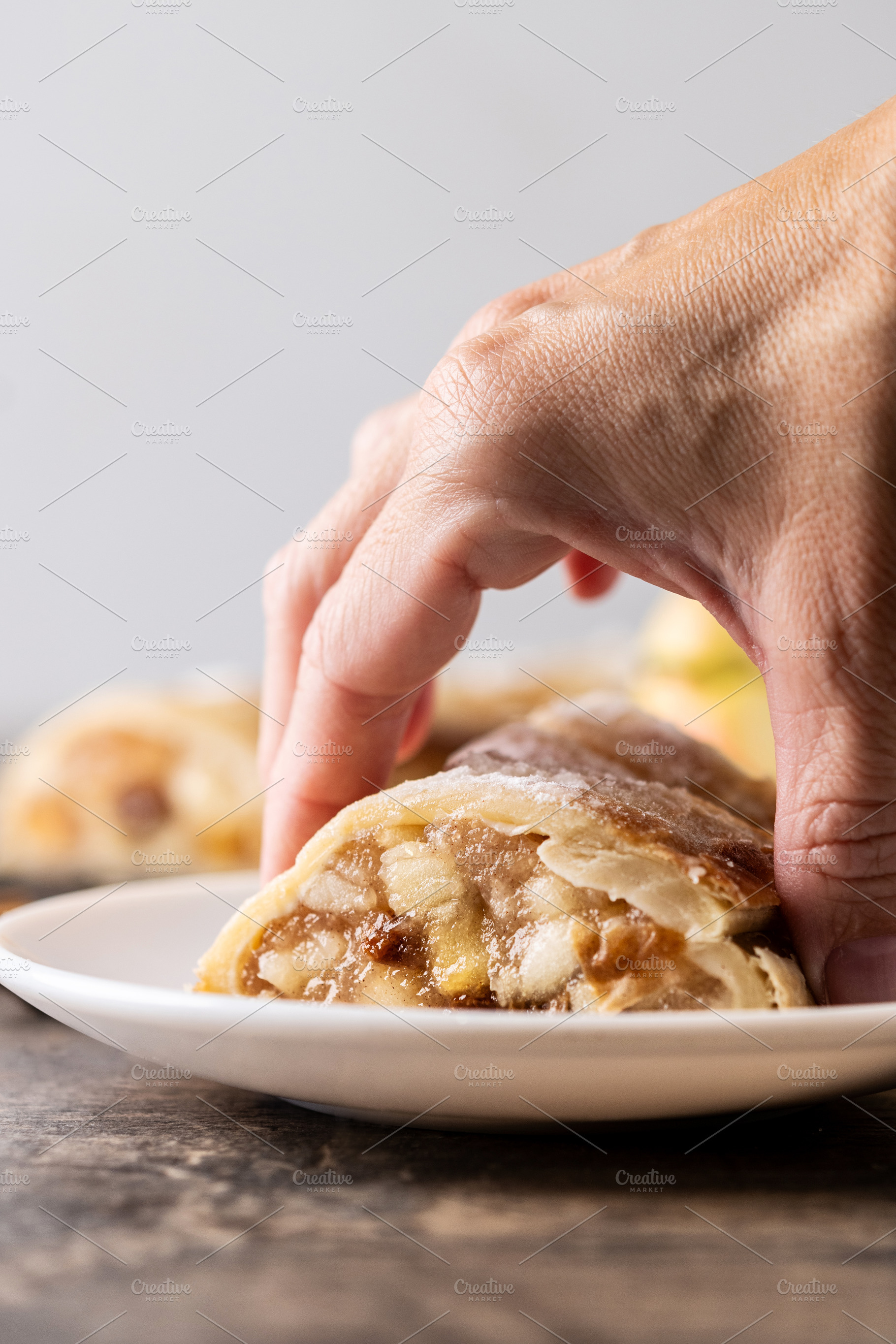 Hand taking two piece of apple strudel, a Food & Drink Photo by etorres69