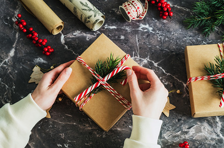 Christmas preparation concept. Female hands wrapping Christmas gift box on ston, a Holiday Photo by photoguns