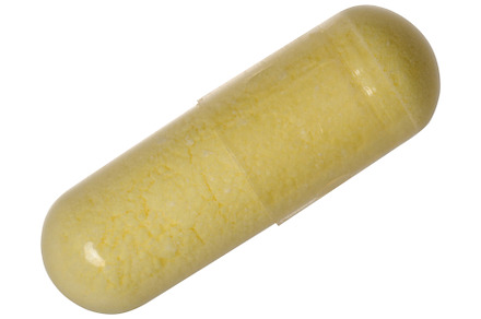 Transparent capsule with yellow powder on isolated background, a Health & Medical Photo by ndanko