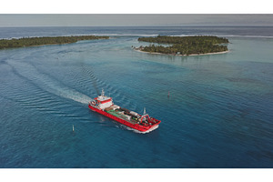 Red cargo ship sailing near tropical, a Transportation Photo by Goinyk