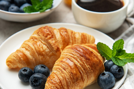 Delicious french breakfast with croissants, coffee, honey and fr
