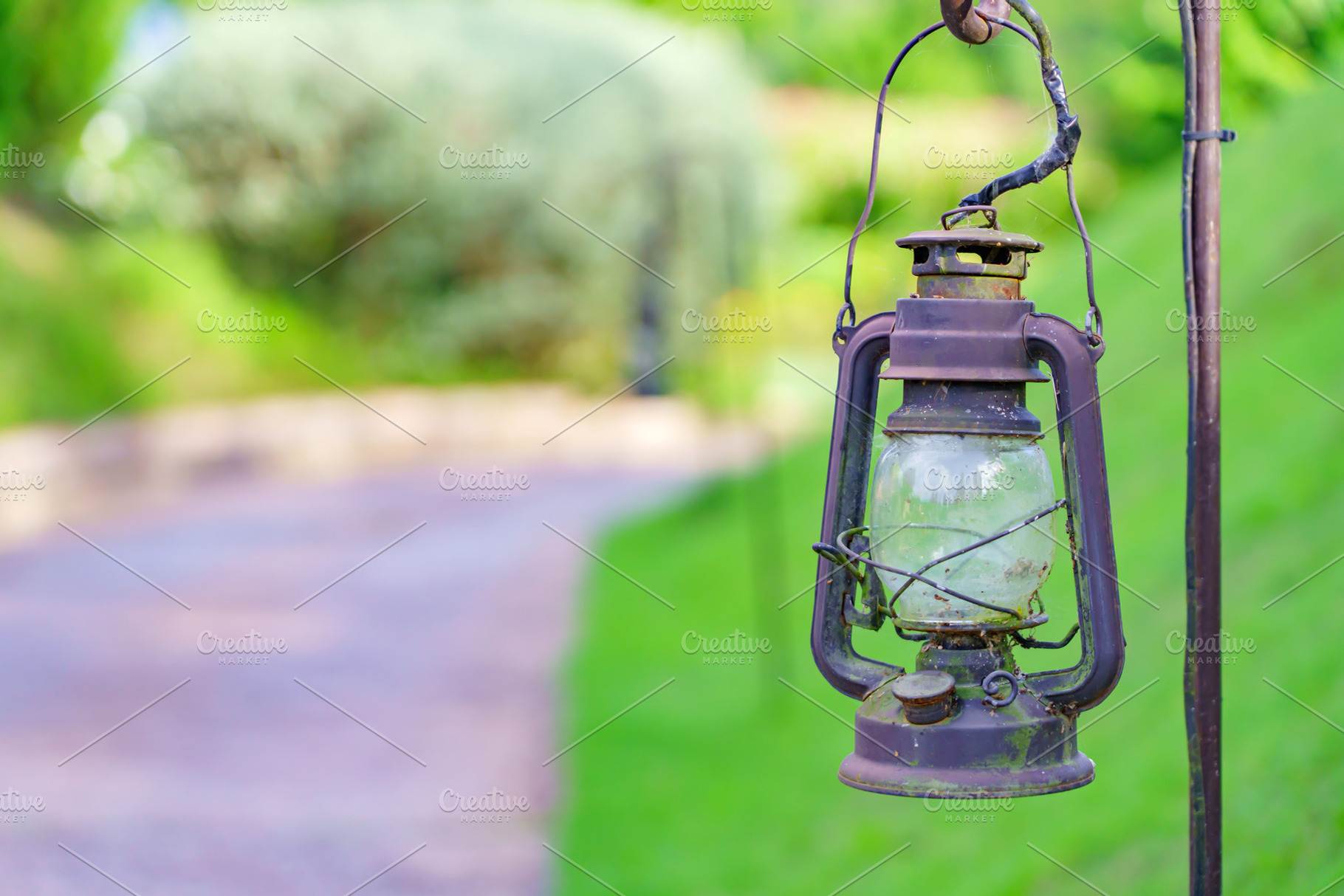 Vintage lamp on footpath with green meadow field, a Nature Photo by Casanowe-studio