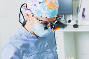 Dentist wearing magnifying glasses performing dental checkup, a Health & Medical Photo by Antonio Gravante Market