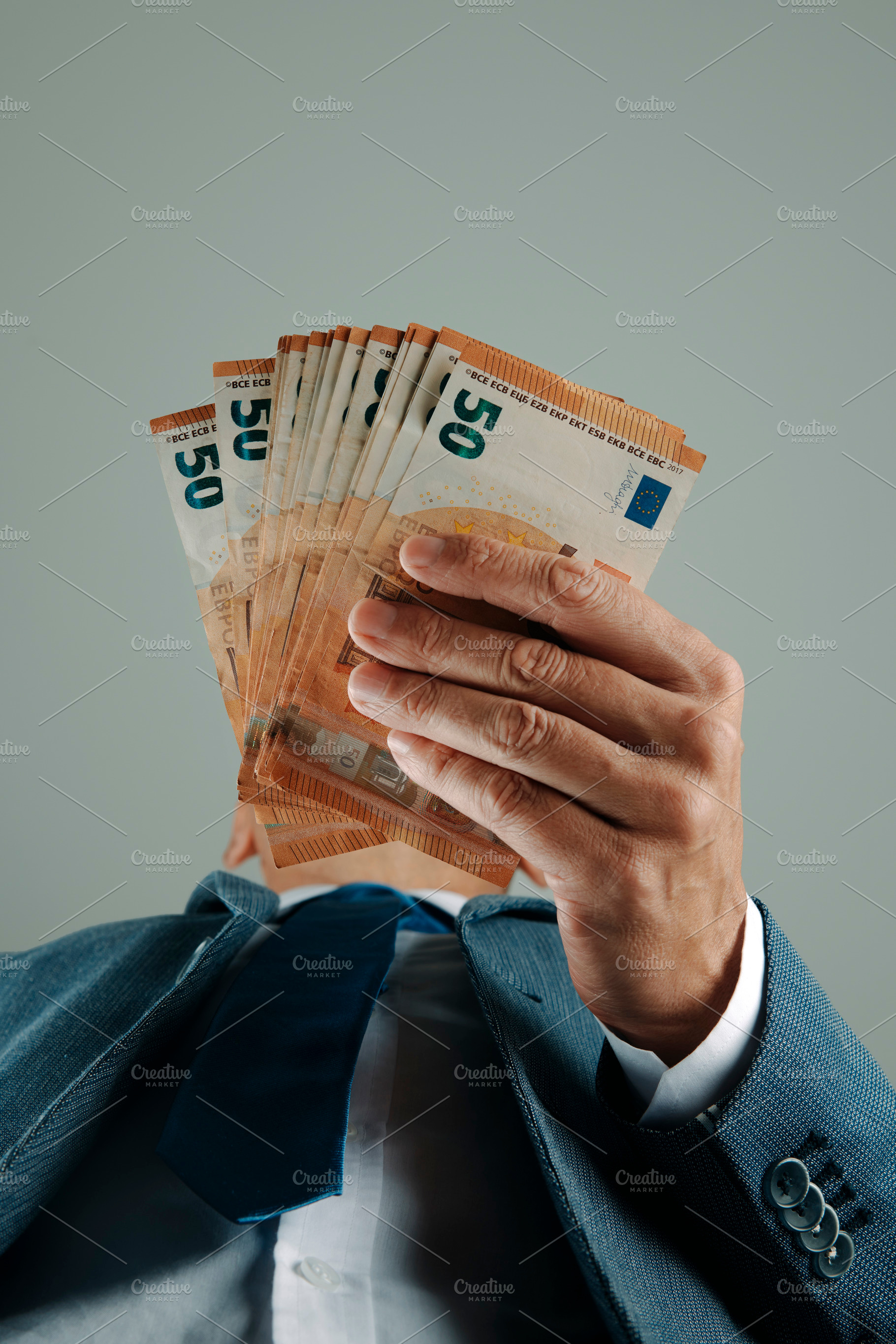 businessman seen from below has some euros, a Photo by Nito