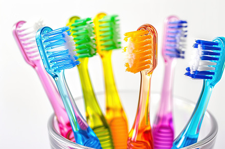 New toothbrushes in glass on white background, a Health & Medical Photo by AlyaAnd
