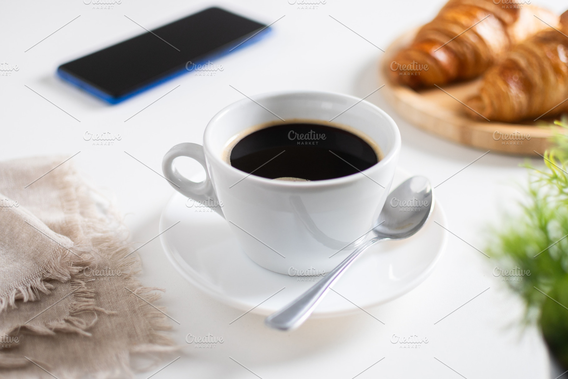Black Coffee Cup on White Table with Croissants and Smartphone, a Food & Drink Photo by etorres69