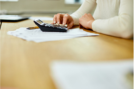 Woman hand using calculator for, a Business Photo by IlliaBondarPhotography