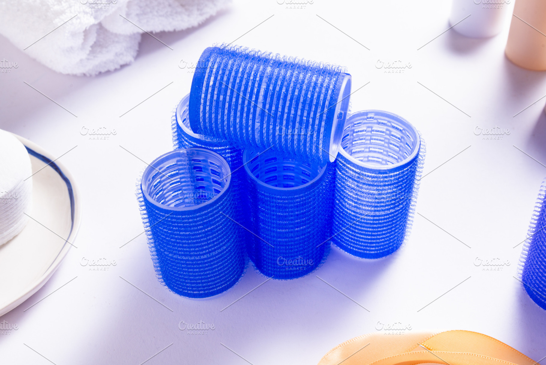 Set of Blue Plastic Hair Rollers with Hair Care Products on Whit, a Business Photo by MDBildes