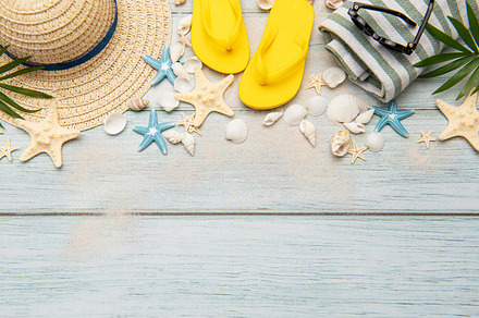 Summer accessories creating a frame on a wooden background with