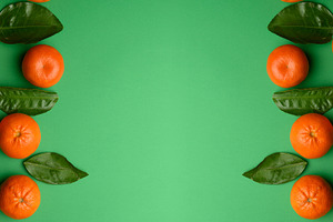 Ripe tangerines with green leaves on a bright green background,, a Food & Drink Photo by ndanko