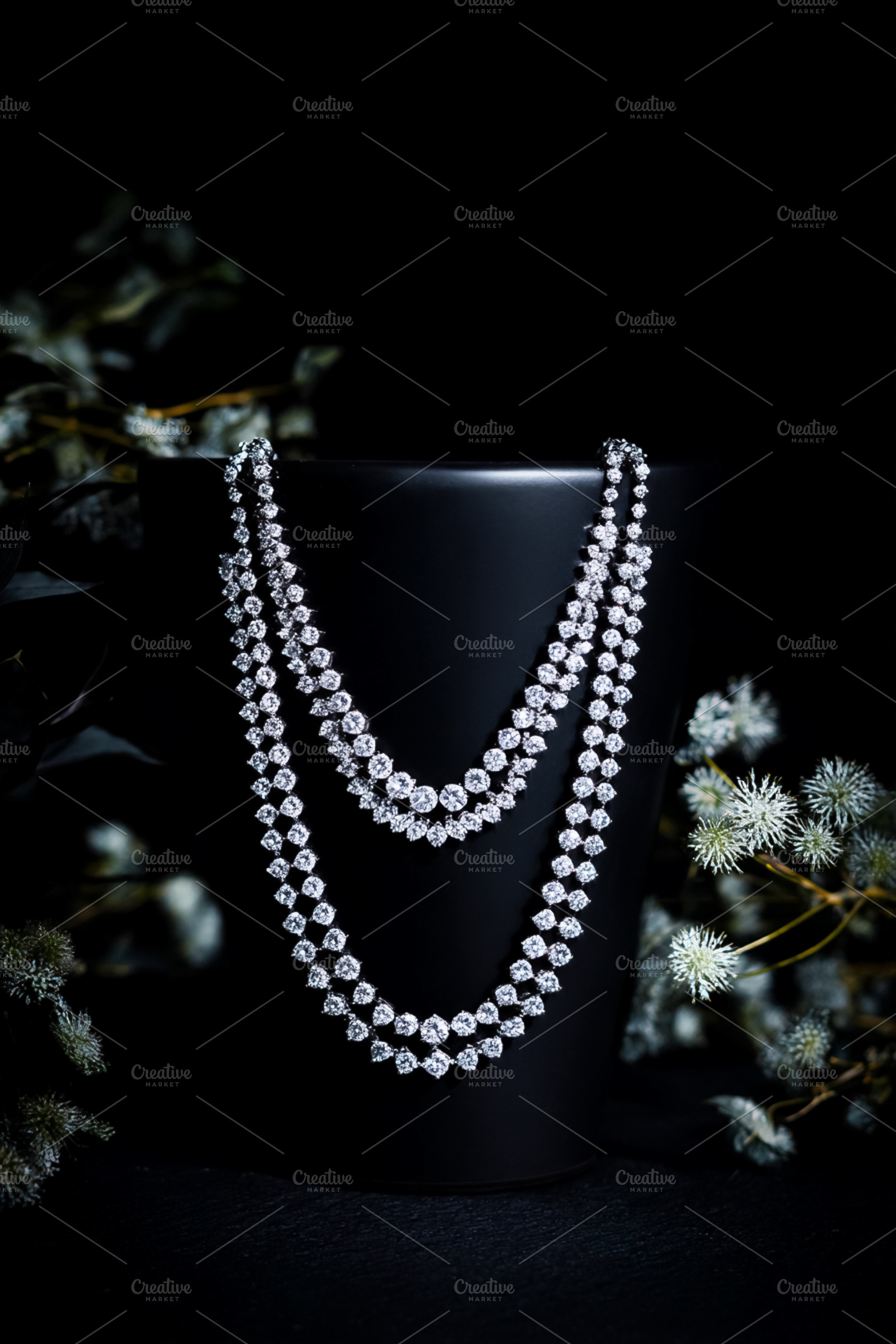 Elegant diamond necklace draping a black stand, sparkling on a d, a Photo by Studio ANNA