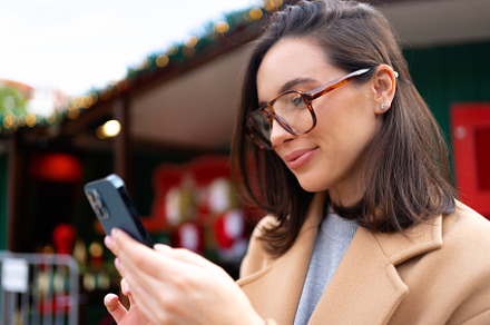 Woman in glasses using mobile phone at day in the city, a Person Photo by andreonegin market