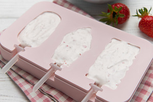 Making homemade strawberry ice cream popsicles in silicone mold, a Food & Drink Photo by Olena Rudo