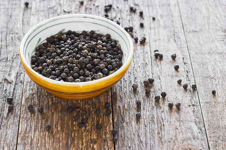 Bowl of black pepper on wooden table featuring pepper, black, and spice, a Food & Drink Photo by AksanaYasi