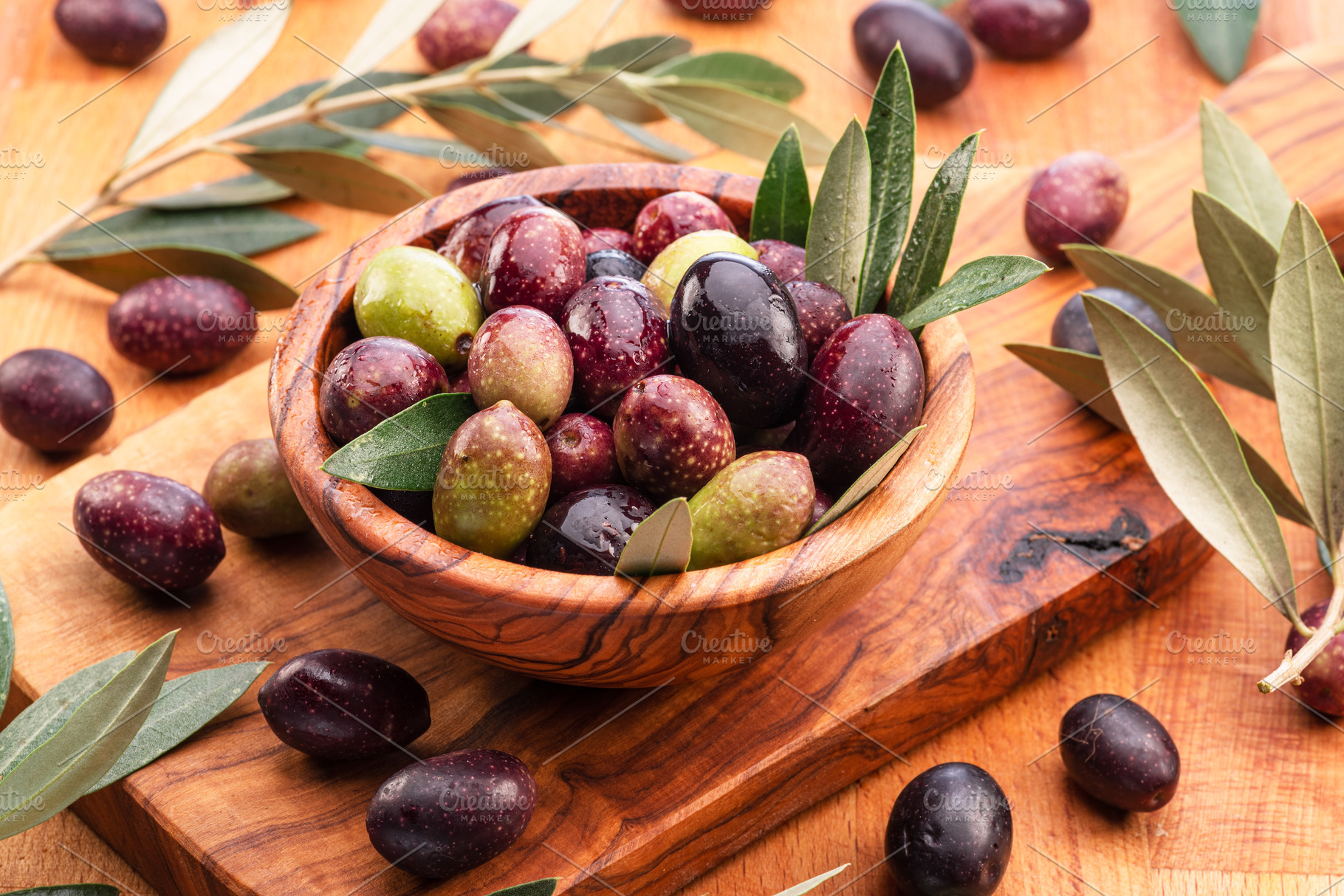 Fresh olives in wooden bowl on the wood background., a Food & Drink Photo by Volff