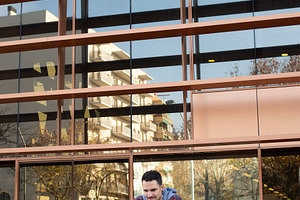 Caucasian man using smartphone in front of modern office, a Person Photo by RF Images