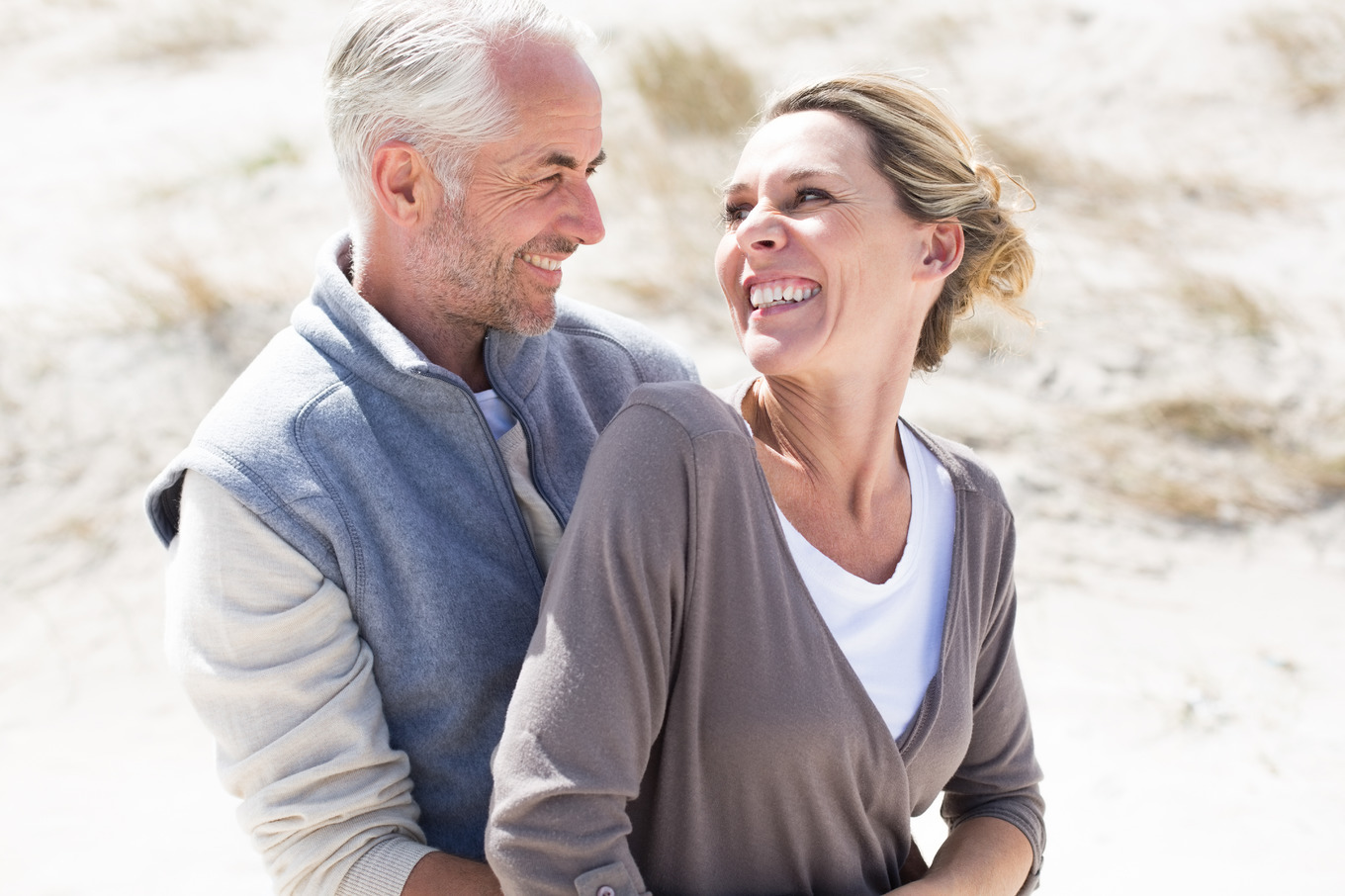 Happy hugging couple on the beach looking at each other, a Photo by ...
