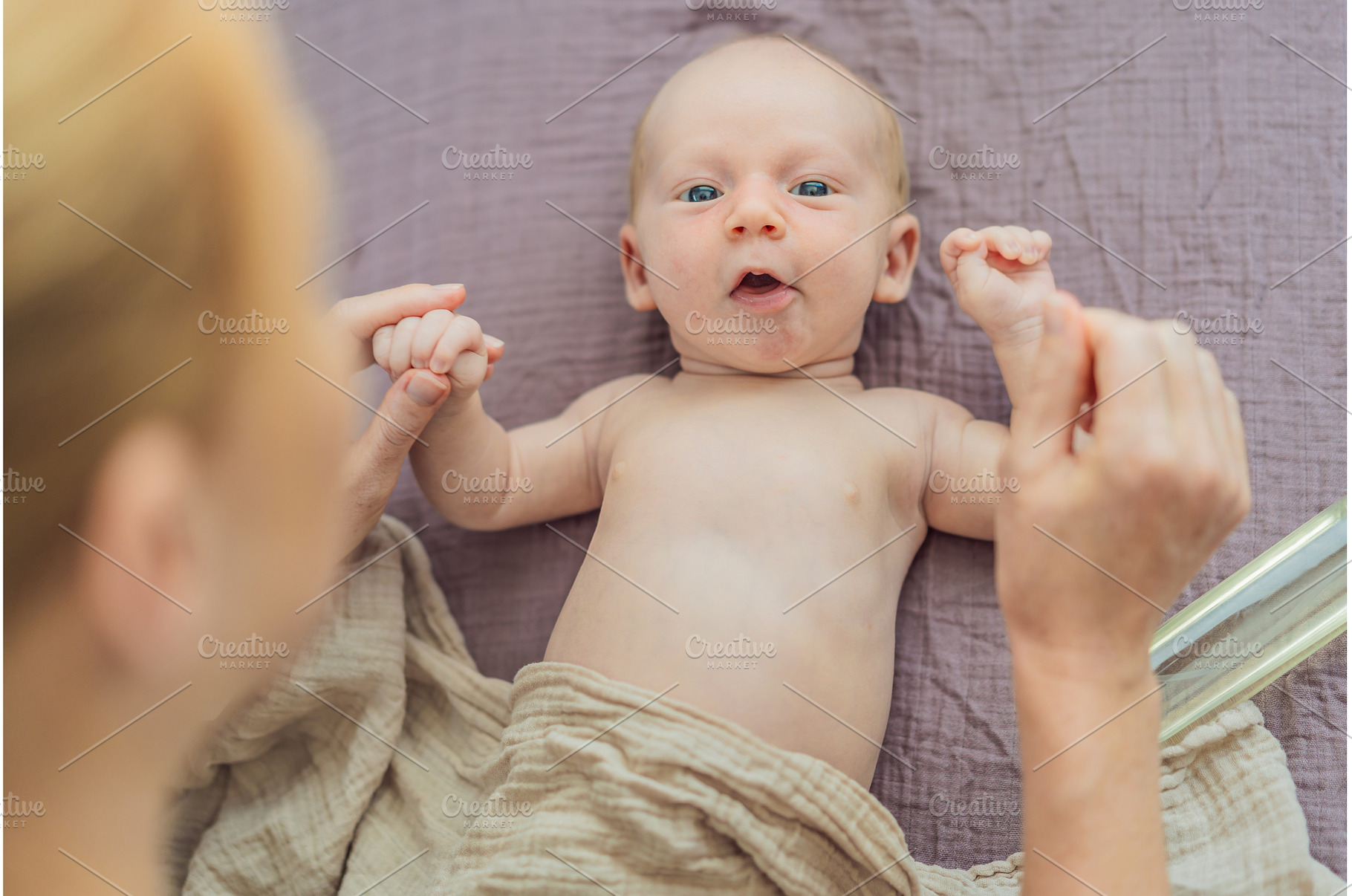 A mother gently massages her 1-month, a Person Photo by Elizaveta Galitskaya