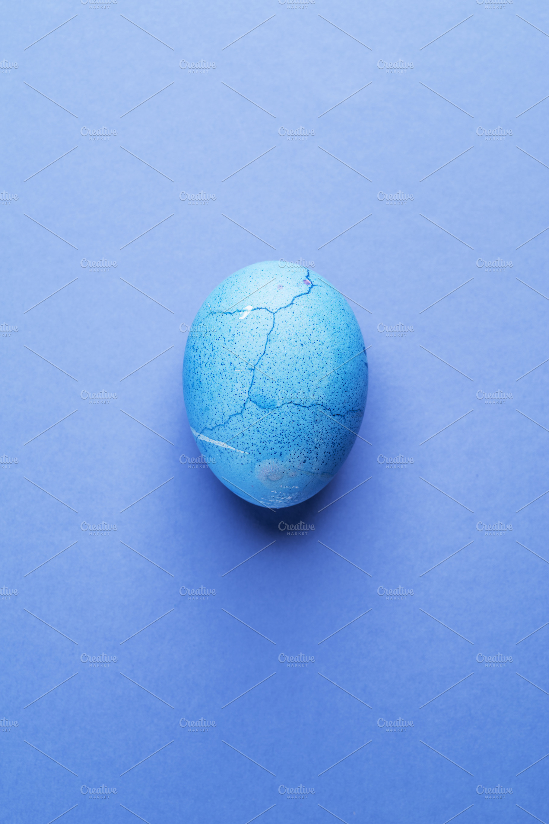 Stained in blue Easter egg on blue, a Photo by Volff
