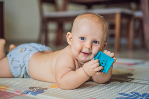 Smiling baby playing with a textured, a Person Photo by Elizaveta Galitskaya