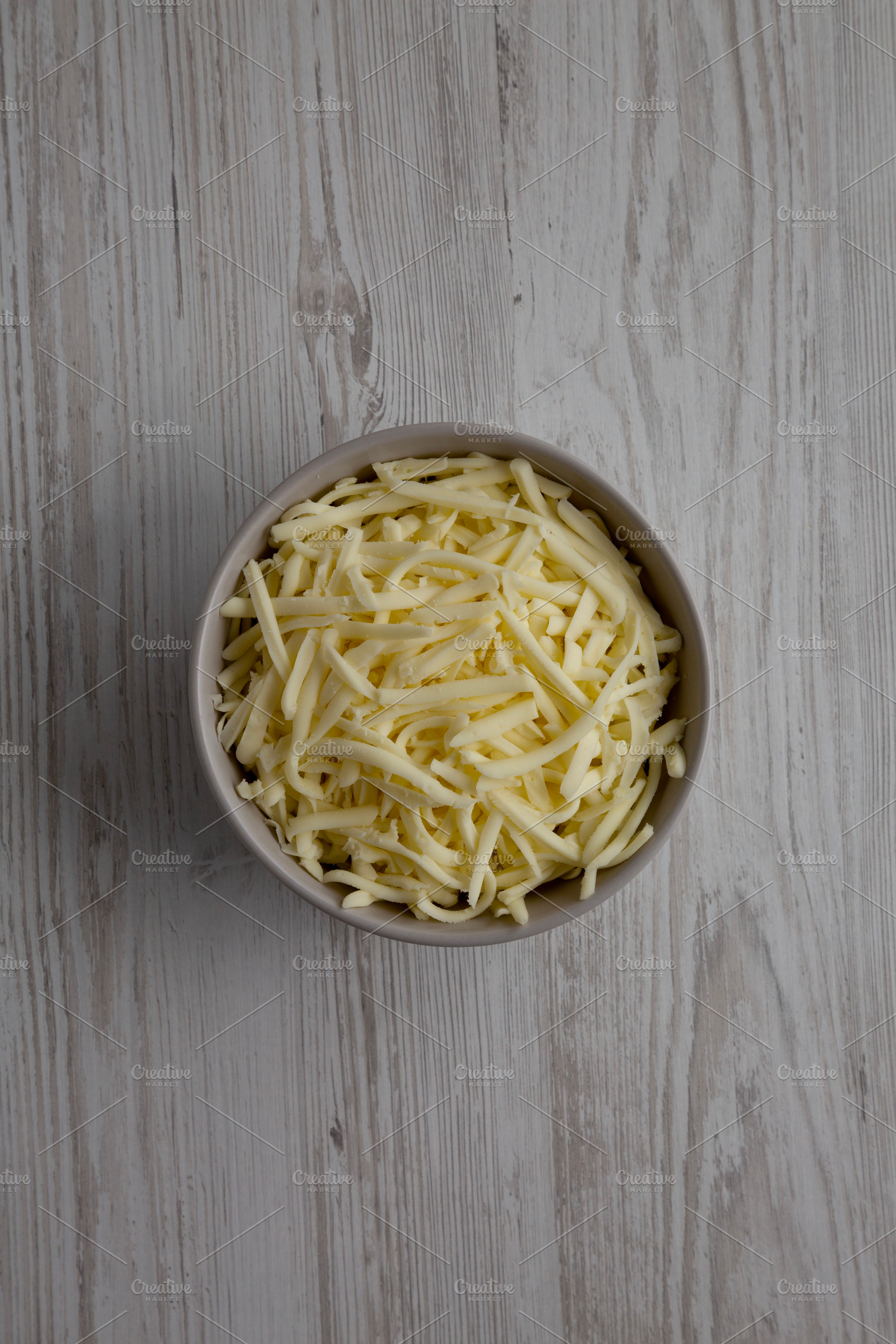 Shredded Mozzarella Cheese in a Bowl, top view. Overhead, from a, a Food & Drink Photo by LiudmylaChuhunova