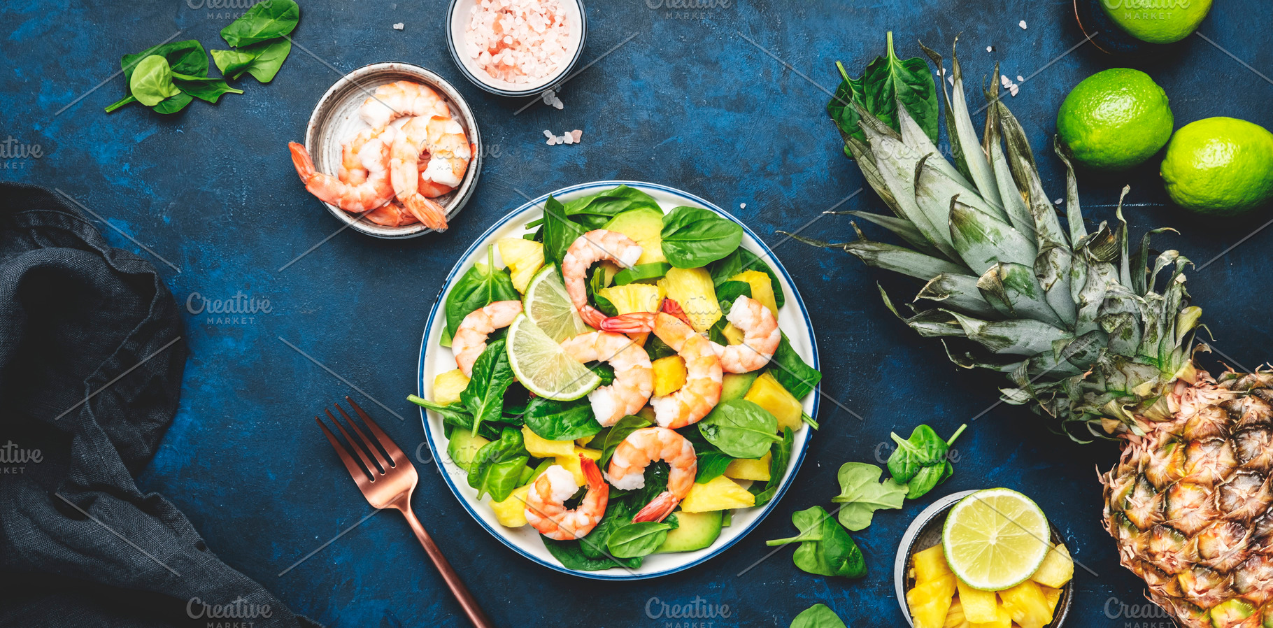 Pineapple salad with shrimps, spinach, avocado and lime on blue, a Food & Drink Photo by 5PH