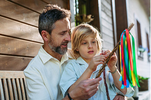 Father and boy braiding easter whip, a Holiday Photo by HalfPoint