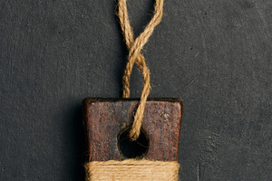 An old cutting board handle made of dark wood, wrapped in natura, a Food & Drink Photo by ndanko