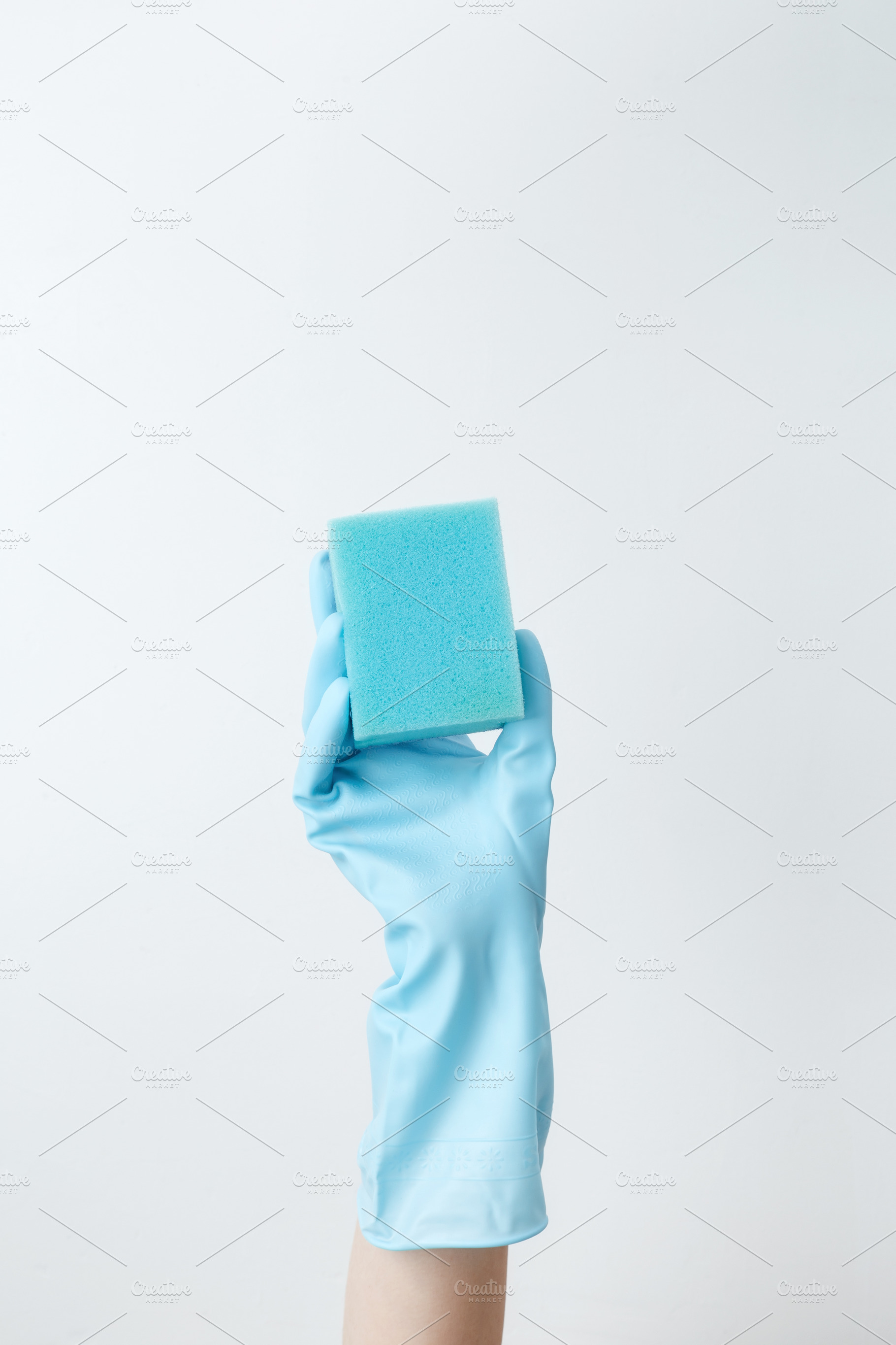 Hand in blue rubber glove holding a sponge for cleaning. Household cleaning and, a Photo by matucha