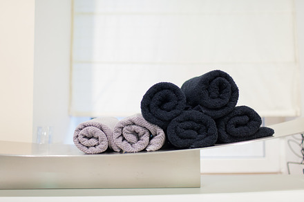 Pink and black rolled-up towels in the Spa, an Abstract Photo by Budarinphoto