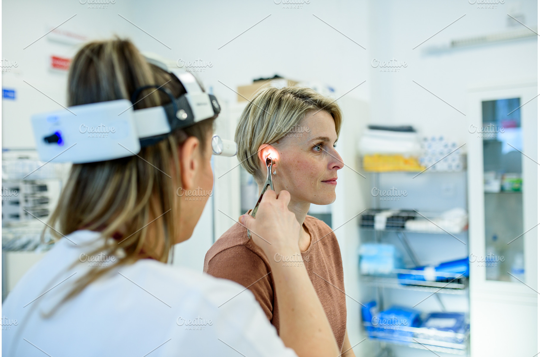 Female patient undergoing ear check, a Health & Medical Photo by HalfPoint