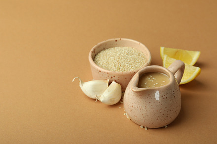 Concept of tasty food with tahini sauce on beige background, a Food & Drink Photo by AtlasStudio PRO