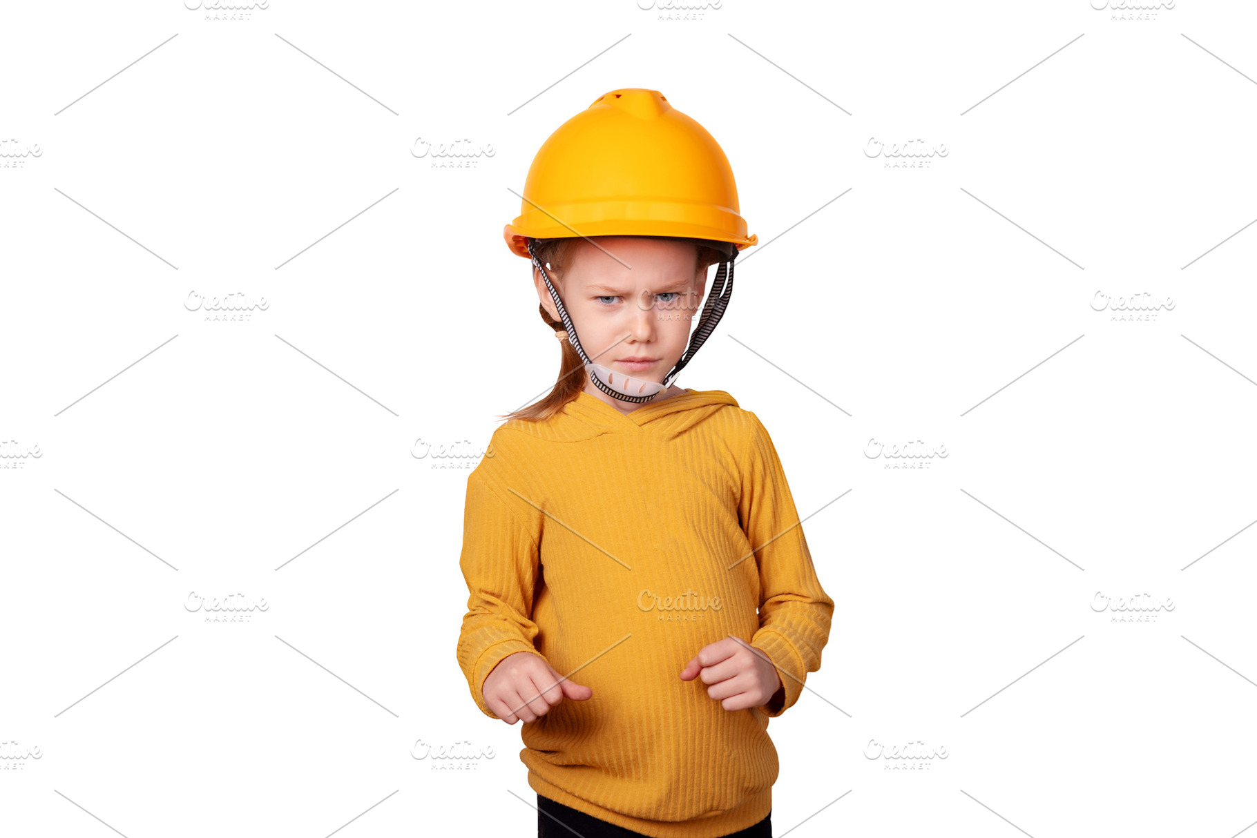 Young child in yellow safety helmet and sweater stands with a co, a Person Photo by Ales Munt