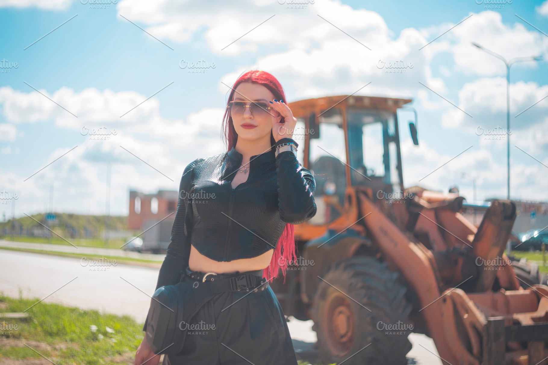 Confident red haired woman in sunglasses posing near industrial, a Photo by Pictures for you!!!!!!!!!