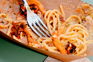 leftovers of two pasta dishes on a green table, a Photo by Nito
