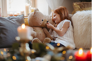 Small girl sitting on sofa indoors, a Person Photo by HalfPoint