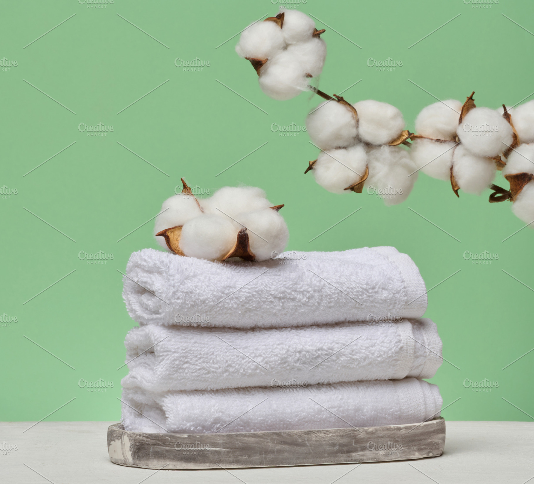 A stack of white folded towels lies on a marble stand, with natu, a Beauty & Fashion Photo by ndanko