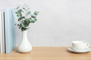 Eucalyptus branches, books, and coffee cup creating a cozy atmos, a Background Photo by Olena Rudo