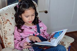 A girl reading comics at sofa, a Person Photo by DanFLCreativo