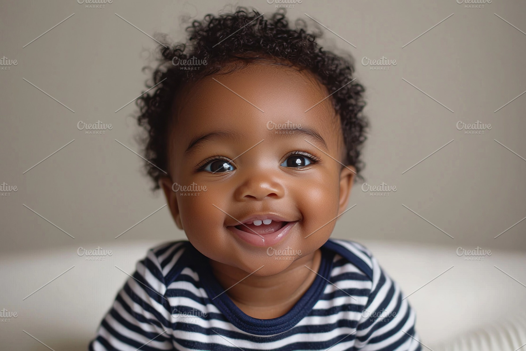 Smiling toddler with curly hair and striped shirt against neutra, a Person Photo by José Manuel Gelpi