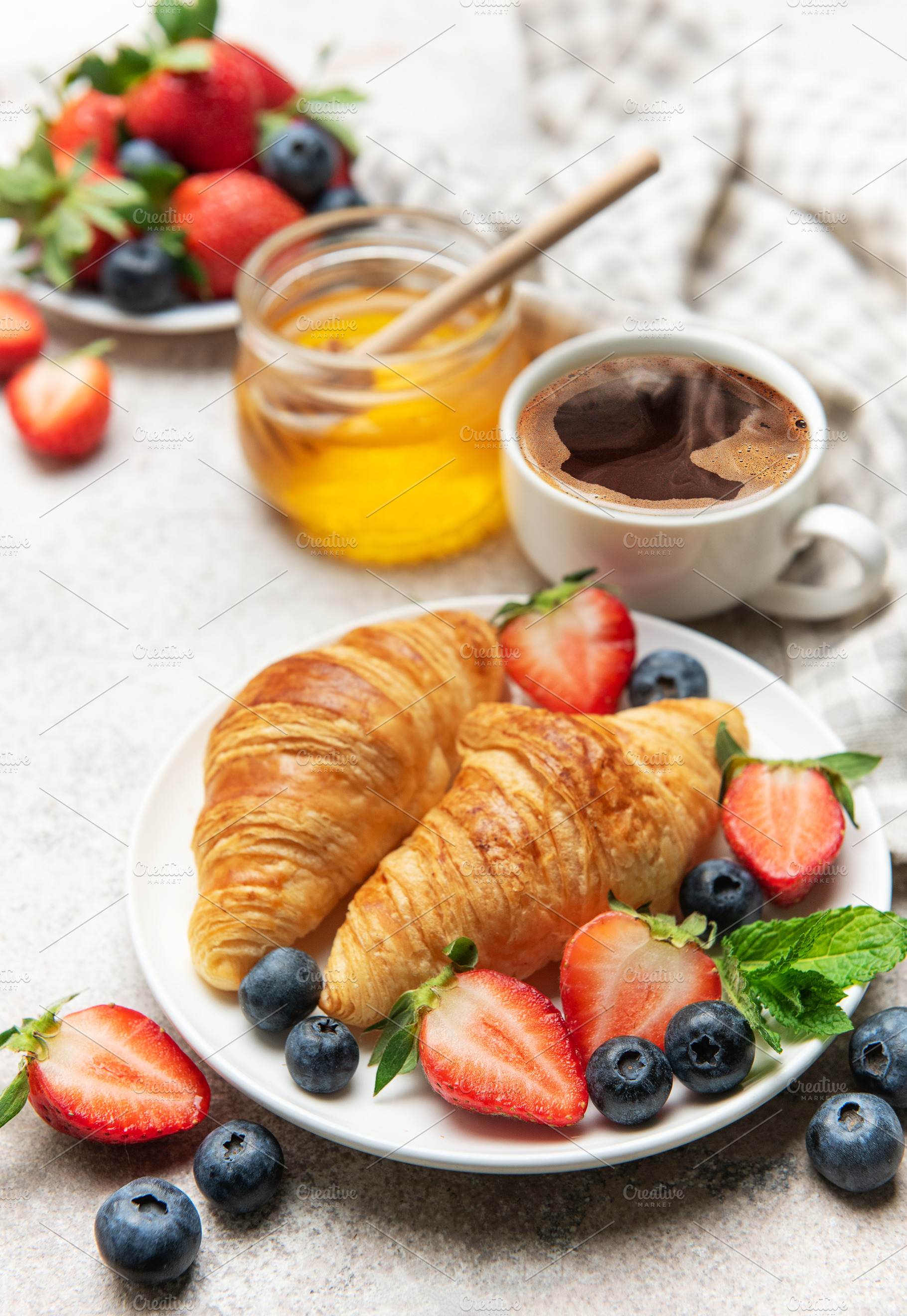 Delicious breakfast with croissants, coffee, berries and honey e, a Food & Drink Photo by Olena Rudo