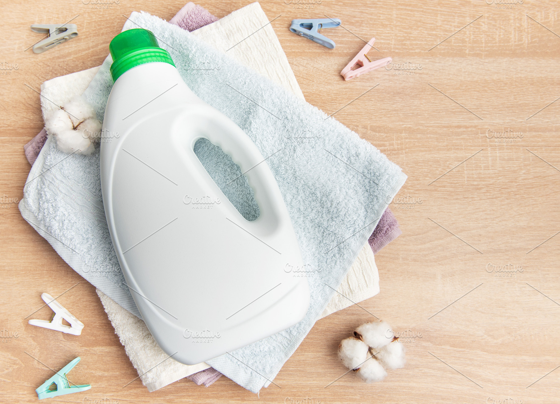 Laundry detergent bottle with towels, cotton and clothespins, an Industrial Photo by Olena Rudo