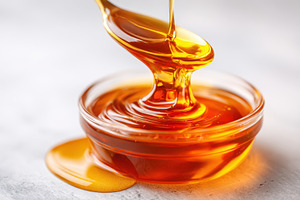 Golden honey pouring into glass bowl, a Food & Drink Photo by AlyaAnd