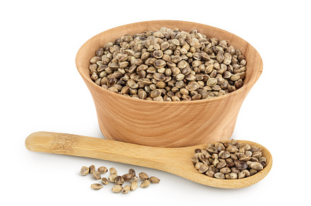 Hemp seeds in wooden bowl isolated, a Food & Drink Photo by NataPhoto