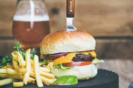 Classic burger dinner with glass of beer and french fries, a Food & Drink Photo by Foxys