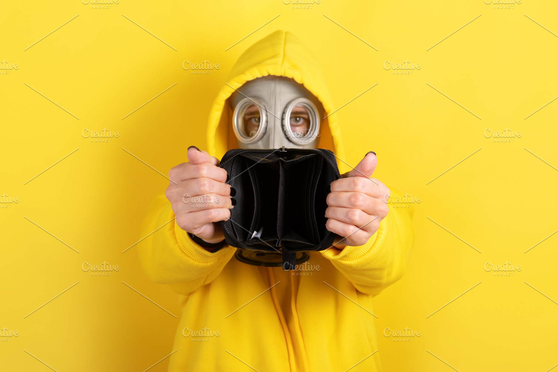 Individual in yellow hoodie and gas mask holding an open empty w, a Person Photo by Ales Munt