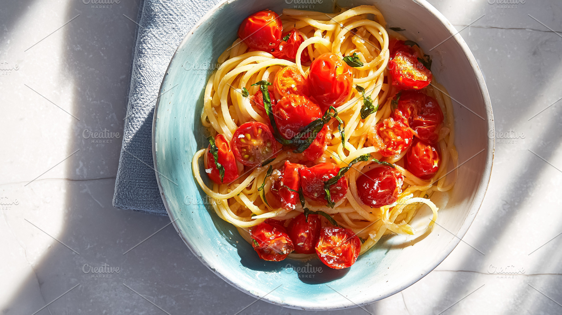 Spaghetti with juicy roasted cherry tomatoes and fresh basil lea, a Photo by Studio ANNA