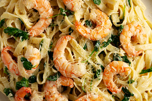 Homemade Creamy One-Pot Spinach Shrimp Pasta on a Plate, top vie, a Food & Drink Photo by LiudmylaChuhunova