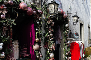 Festive decorated storefront on a cobblestone street in Óbidos, Portugal, a Photo by AS photostudio
